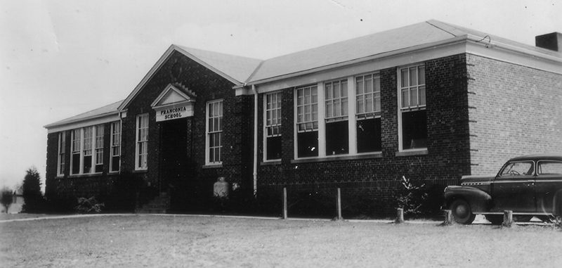 Black and white photograph of the original main entrance of Franconia Elementary School taken in 1942 for the Fairfax County School Board’s Fire Insurance Survey. A late 1930s-era car is visible to the right. 
